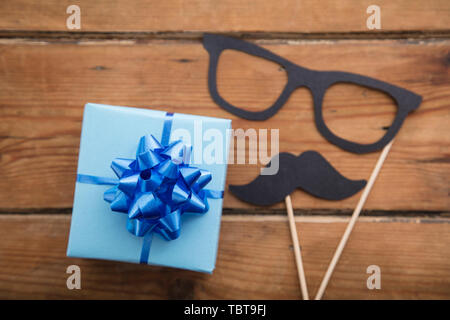 Des pères cadeaux enveloppés de papier bleu avec moustache. Happy father's day background Banque D'Images