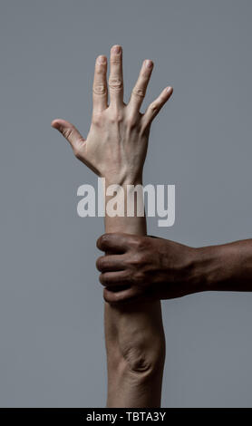 Black African American main tenant le bras de la peau blanche. Image conceptuelle de campagne humanitaire pour aider les réfugiés et arrêter les questions de racisme. L'unité du monde Banque D'Images