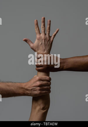 Black African American and Caucasian hands holding ensemble. La peau blanche et noire dans les bras des mondiale contre le racisme, d'amour et de compréhension r Banque D'Images