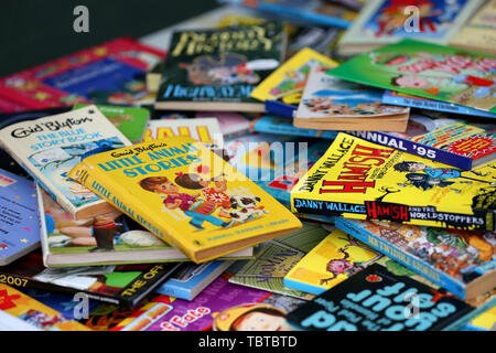 Pile de livres pour enfants en vente sur un étal de bienfaisance dans la région de Sussex, UK. Banque D'Images