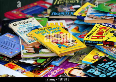 Pile de livres pour enfants en vente sur un étal de bienfaisance dans la région de Sussex, UK. Banque D'Images