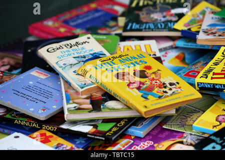 Pile de livres pour enfants en vente sur un étal de bienfaisance dans la région de Sussex, UK. Banque D'Images