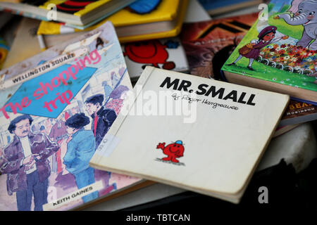 Pile de livres pour enfants en vente sur un étal de bienfaisance dans la région de Sussex, UK. Banque D'Images