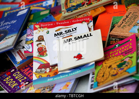 Pile de livres pour enfants en vente sur un étal de bienfaisance dans la région de Sussex, UK. Banque D'Images