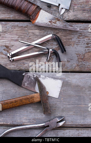 Ensemble d'outils et instruments, vue d'en haut. Vieux grungy tool set y compris marteau, pinces, le couteau et la spatule en bois gris sur l'arrière-plan. Banque D'Images