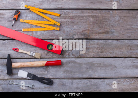 Outils de travail sur fond de bois. Kit d'outil y compris spatule, marteau, pinceau, un niveau à bulle, règle de pliage et de tournevis. L'espace pour le texte. Banque D'Images