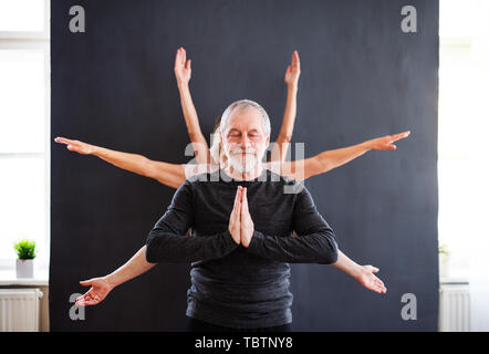 Man avec une multiplicité de bras faisant du yoga de l'exercice dans le centre de la communauté club. Banque D'Images