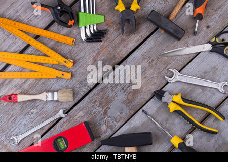 Outils de construction frame sur fond rustique. Mise à plat des différents outils du technicien sur les anciennes planches de bois. Banque D'Images