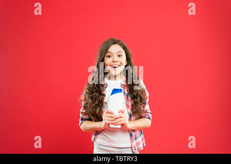 Des cheveux forts et sains. Fraîcheur durable. C'est fraîche. Petit enfant les cheveux longs. Bouteille de shampooing. Kid active fille aux cheveux longs. Shampooing Sec. Conseils faciles à faire hairstyle pour les enfants. Banque D'Images