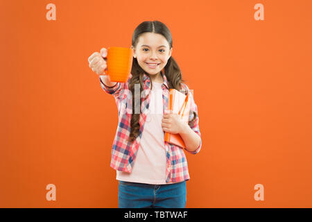 La littérature pour enfants. Aime passer du temps à la maison. Cacao chaud et bon livre idéal pour soirée agréable. Lecture bucket list. Dépenser temps agréable avec livre préféré. Fille tenir une tasse de thé et d'adresses. Banque D'Images