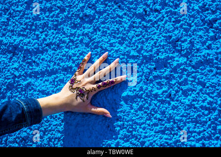 Bras avec un tatouage au henné traditionnel sur l'arrière-plan de la mur bleu. Rabat, Maroc. Afrique du Sud Banque D'Images