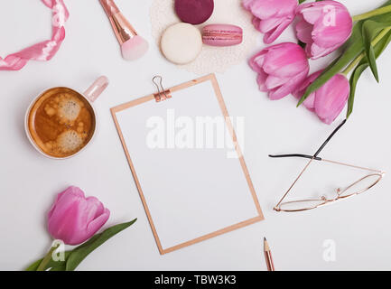 Lieu de travail de style féminin avec des tulipes et du café. Maquette du presse-papiers Banque D'Images