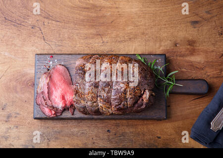 Rôti de boeuf sur une planche à découper en bois avec des cornichons. Vue d'en haut. Copier l'espace. Banque D'Images