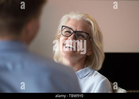 Belle mature businesswoman laughing at collègue Joke pendant les pauses Banque D'Images