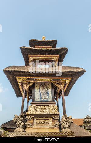 Ubud, Bali, Indonésie - 26 Février 2019 : Batuan Temple. Libre de peinture sur le côté de l'idole petit sanctuaire avec toits reed triple contre le ciel bleu. Banque D'Images