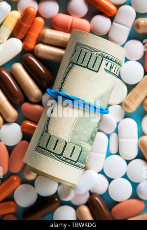 Roulé tas de billets de dollars USD au cours de la medical pills. La médecine, l'industrie des soins de santé et le trafic de drogue. Haut en bas macro-vision. Banque D'Images