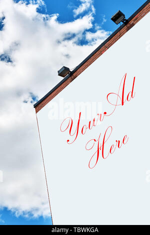 Blank billboard énorme sur un bâtiment en briques rouges contre fond de ciel bleu avec des nuages par une belle journée ensoleillée Banque D'Images