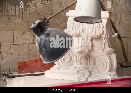 L'élément décoratif fait de gypse. Le travail du sculpteur dans l'atelier. Banque D'Images