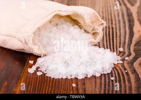 Le sel de mer en sac de jute sur table en bois Banque D'Images