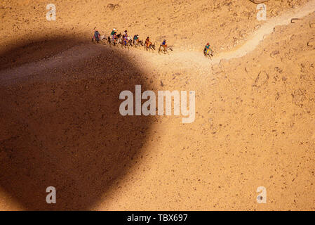 Photo : © Simon Grosset. La montgolfière sur la Vallée des Rois, Louxor, Egypte. L'ombre du ballon passe au-dessus des touristes sur un âne ou h Banque D'Images