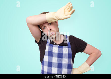 Homme portant des gants de caoutchouc pour la protection des mains essuyant la sueur Banque D'Images