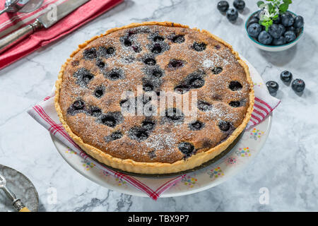 Tarte aux bleuets et amandes saupoudrés de sucre glace Banque D'Images