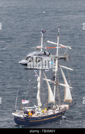 La Royal Australian Navy (RAN) de l'hélicoptère Bell 429 N49-048 survolant le port de Sydney avec un grand voilier en arrière-plan. Banque D'Images