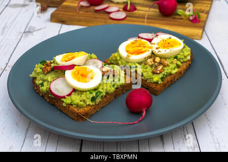 Des sandwichs avec avocado guacamole et radis frais oeuf dur - prêt Banque D'Images