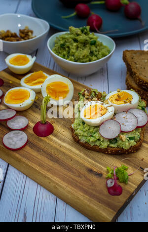 Des sandwichs avec avocado guacamole et radis frais oeuf dur - prêt Banque D'Images