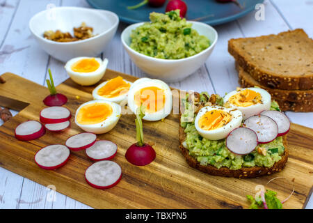 Des sandwichs avec avocado guacamole et radis frais oeuf dur - prêt Banque D'Images