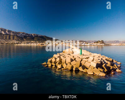 Vue aérienne du port de Denia. Brise-lames et un phare à l'avant-plan. La ville et la montagne Montgo dans l'arrière-plan. Banque D'Images