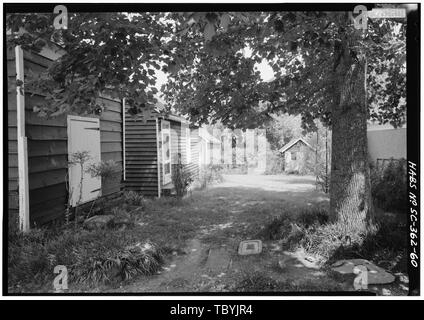 Mai 1985. Au NORD-OUEST DE DÉPENDANCES À LA MAISON PRINCIPALE, AU NORD LE LONG DE FRONTIÈRE EST ALLEE AU PRINTEMPS (la cour en milieu de vue utilisé pour être un poulailler. Dépendances, de gauche à droite Smokehouse, lavoir, maison de poulet, poulet couveuse, puis garage pour droit d'arbre. Structure de métal en vue de gauche de l'arbre est tour pour antenne de télévision. Arbre en premier plan est un tulipier, Liriodendron tulipifera.) Quartier Maison, côté ouest de la Route 261, à environ 150 m du côté sud de la jonction avec l'ancienne lauréate de Ferry Road, Stateburg, Sumter Comté, SC Cornwallis Greene Cary, Brian, le transmetteur pr Banque D'Images