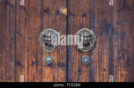 Close-up de tête de lion en cuivre sur la poignée de porte en bois classique chinois Banque D'Images