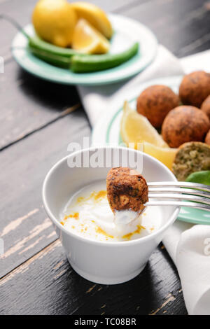 Manger de délicieux Falafel balles avec sauce, closeup Banque D'Images