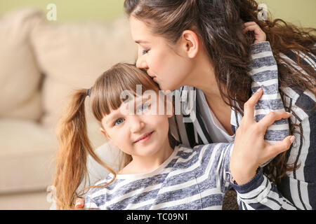 Femme heureuse avec peu adopté girl at home Banque D'Images