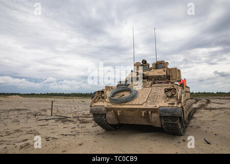 Une armée de combat Bradley M2 véhicule appartenant au 1er bataillon du génie, 1st Armored Brigade Combat Team, 1re Division d'infanterie étapes sur une violation de plage durant l'un essai de rupture à pied la formation dispensée sur une plage près du Camp Trzebień, Pologne, le 23 mai 2019. La formation sur les deux monté et démonté les violations de combat est une partie essentielle de la mission de préparation de la 1ère. Bat. de l'Atlantique au cours de résoudre. (U.S. Photo de l'armée par le Sgt. Jeremiah Woods) Banque D'Images