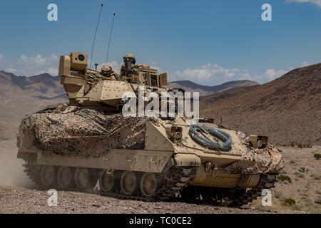 Les soldats du 1er bataillon du 163e régiment de cavalerie, la Garde nationale du Montana, pousser dans leur véhicule de combat Bradley lors d'une attaque défensive d'entraînement au Centre National d'entraînement (NTC) à Fort Irwin, en Californie, le 1 juin 2019. Un mois une rotation NTC offre plus de 4 000 militaires de 31 membres, y compris les unités de la Garde nationale de 13 Etats et territoires, avec l'entraînement réaliste de renforcer leur combat, et de soutenir les capacités de soutien. (Photo : Cpl. Alisha, Grezlik Mobile 115e Détachement des affaires publiques) Banque D'Images