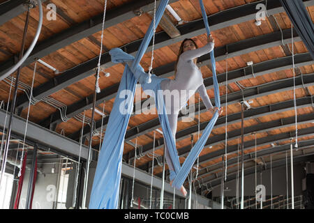 Une belle jeune fille gymnaste est engagé dans fly yoga sur toiles aériennes. Banque D'Images