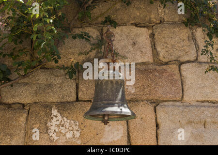 Bell ancienne sur un mur de pierre dans le village abandonné de Granadilla, Cáceres-Espagne Banque D'Images