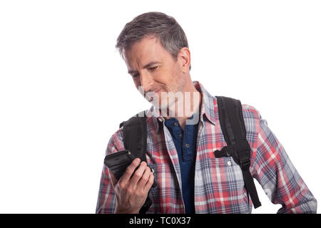 L'homme ou d'un randonneur en utilisant un téléphone cellulaire pour appeler un message ou voyagement afin qu'il puisse voyager. L'homme porte un sac à dos et à l'aide d'un téléphone intelligent. Est Banque D'Images