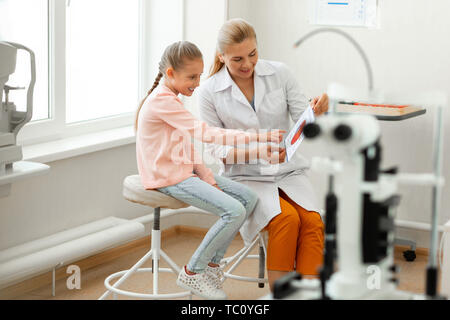 Caractéristiques et de l'élément . Enfant intelligent intéressées appuient demande beau médecin sur la structure de l'œil complexe Banque D'Images