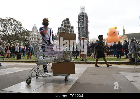 Un homme vend du papier toilette par l'atout de Donald Trump le bébé ballon lors de manifestations dans la place du Parlement, Londres le deuxième jour de la visite d'Etat au Royaume-Uni par le président américain, Donald Trump. Banque D'Images