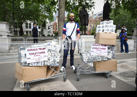 Un homme vend du papier toilette par l'atout de Donald Trump le bébé ballon lors de manifestations dans la place du Parlement, Londres le deuxième jour de la visite d'Etat au Royaume-Uni par le président américain, Donald Trump. Banque D'Images