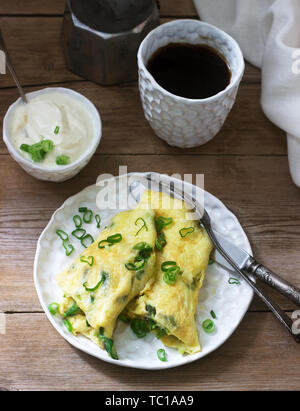 Petit-déjeuner fait maison composé d'omelette aux asperges et d'oignons et du café chaud. De style rustique, selective focus. Banque D'Images