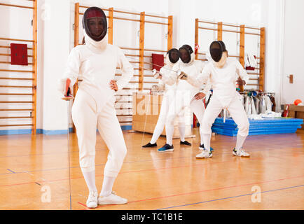 Portrait de jeune femme sportive avec un masque en papier aluminium à l'entraînement d'escrime Banque D'Images