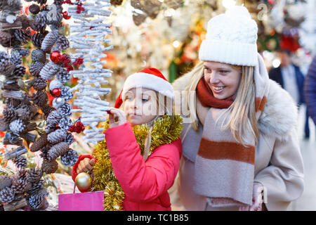 Cute Smiling preteen girl s'amusant sur Noël avec la mère, la sélection de décoration pour la maison Banque D'Images