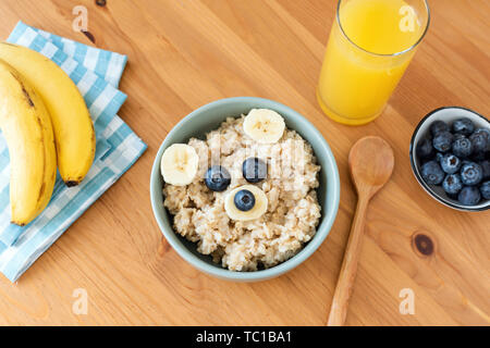 Petit-déjeuner enfants porridge d'avoine en forme d'ours sur une table en bois et verre de jus d'orange. Petit déjeuner d'un sain Banque D'Images