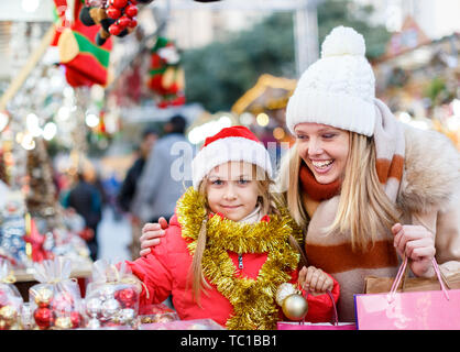 Cute Smiling preteen girl s'amusant sur Noël avec la mère, la sélection de décoration pour la maison Banque D'Images