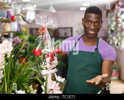 African American male florist positifs des arrangements de fleurs offrant à son magasin de fleur Banque D'Images