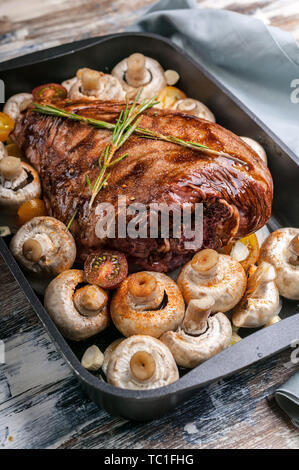 Agneau mariné avec les champignons, les épices et les herbes dans un moule en fonte sur un fond de bois. La viande halal et de l'alimentation. Close-up Banque D'Images